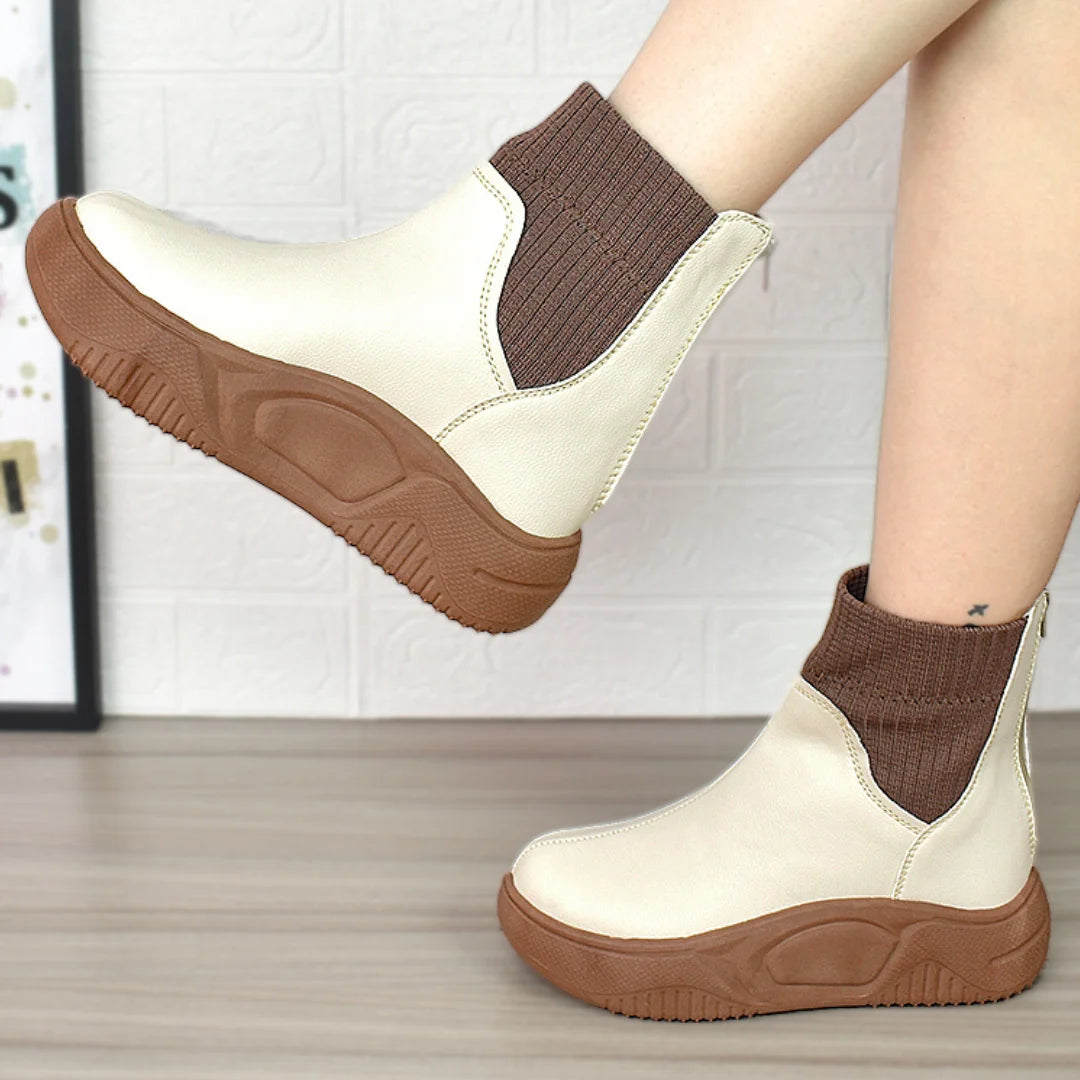 Modelo femenino mostrando Botines Suelaviva Aura en beige desde la rodilla hacia abajo, diseño elegante y cómodo, ideales para cualquier ocasión.
