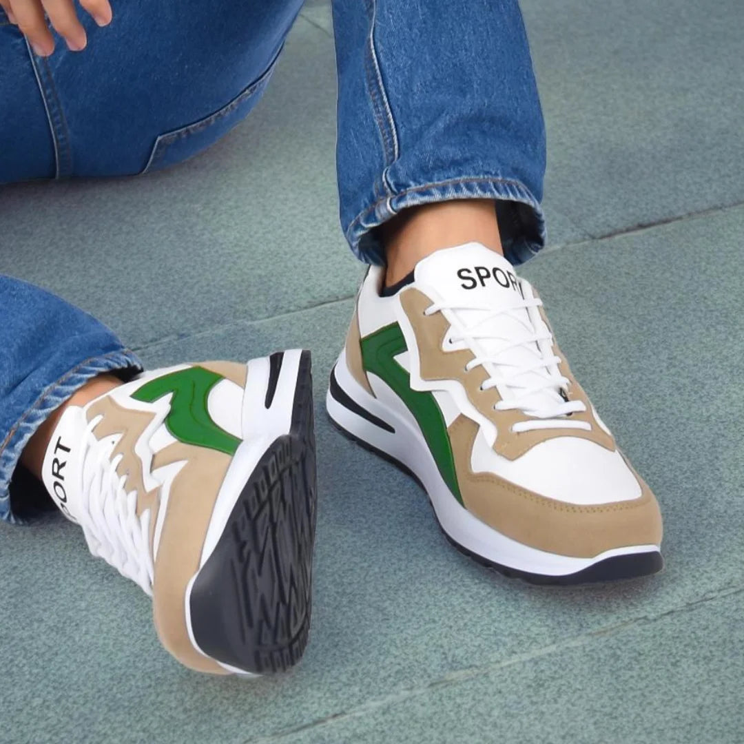 Modelo masculino vistiendo Tenis Suelaviva Rivo en verde desde la rodilla hacia abajo, diseño vibrante y moderno, destacando un estilo y suela dinámica.