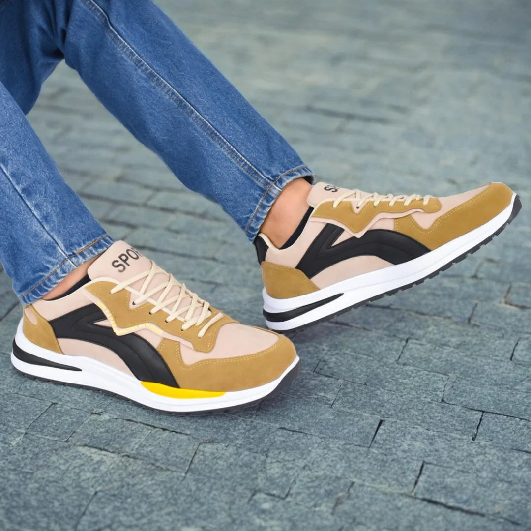 Modelo masculino mostrando Tenis Suelaviva Rivo en beige desde la rodilla hacia abajo, diseño casual y versátil, ideal para cualquier ocasión.