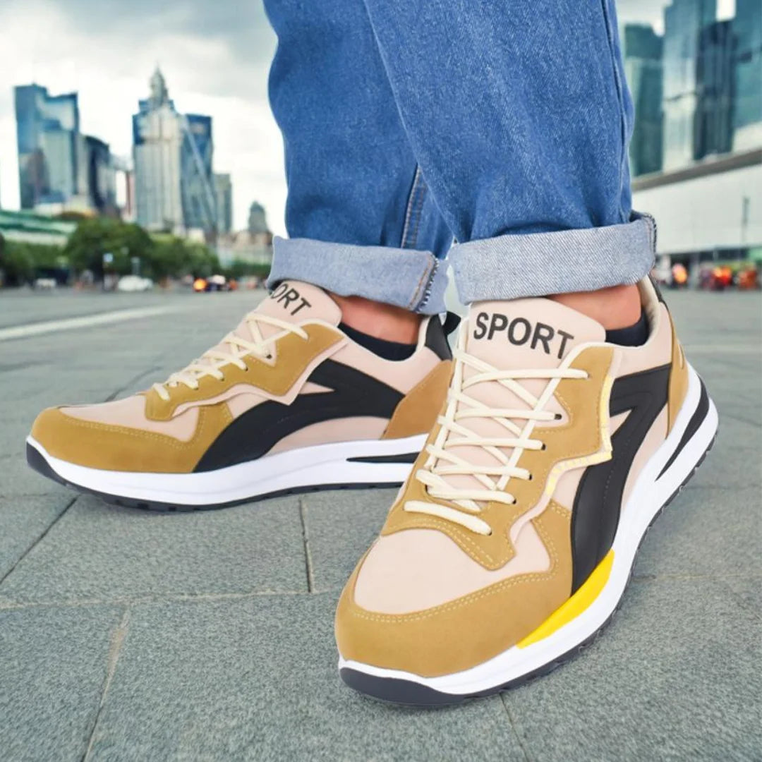 Modelo masculino mostrando Tenis Suelaviva Rivo en beige desde la rodilla hacia abajo, diseño versátil y cómodo, perfecto para el día a día.