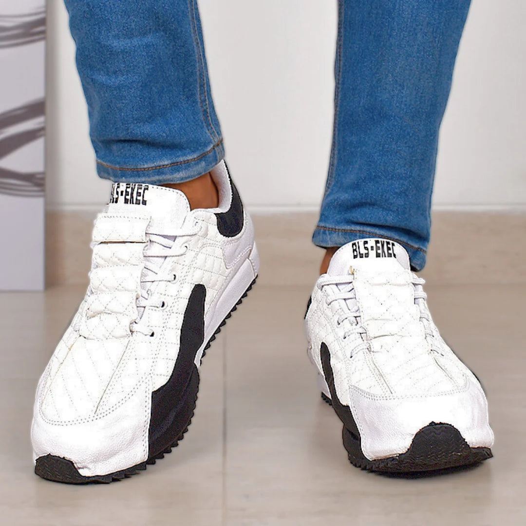 Modelo masculino luciendo Tenis Suelaviva San en blanco desde la rodilla hacia abajo, diseño vibrante y moderno al estilo coreano, perfectos para outfits activos.